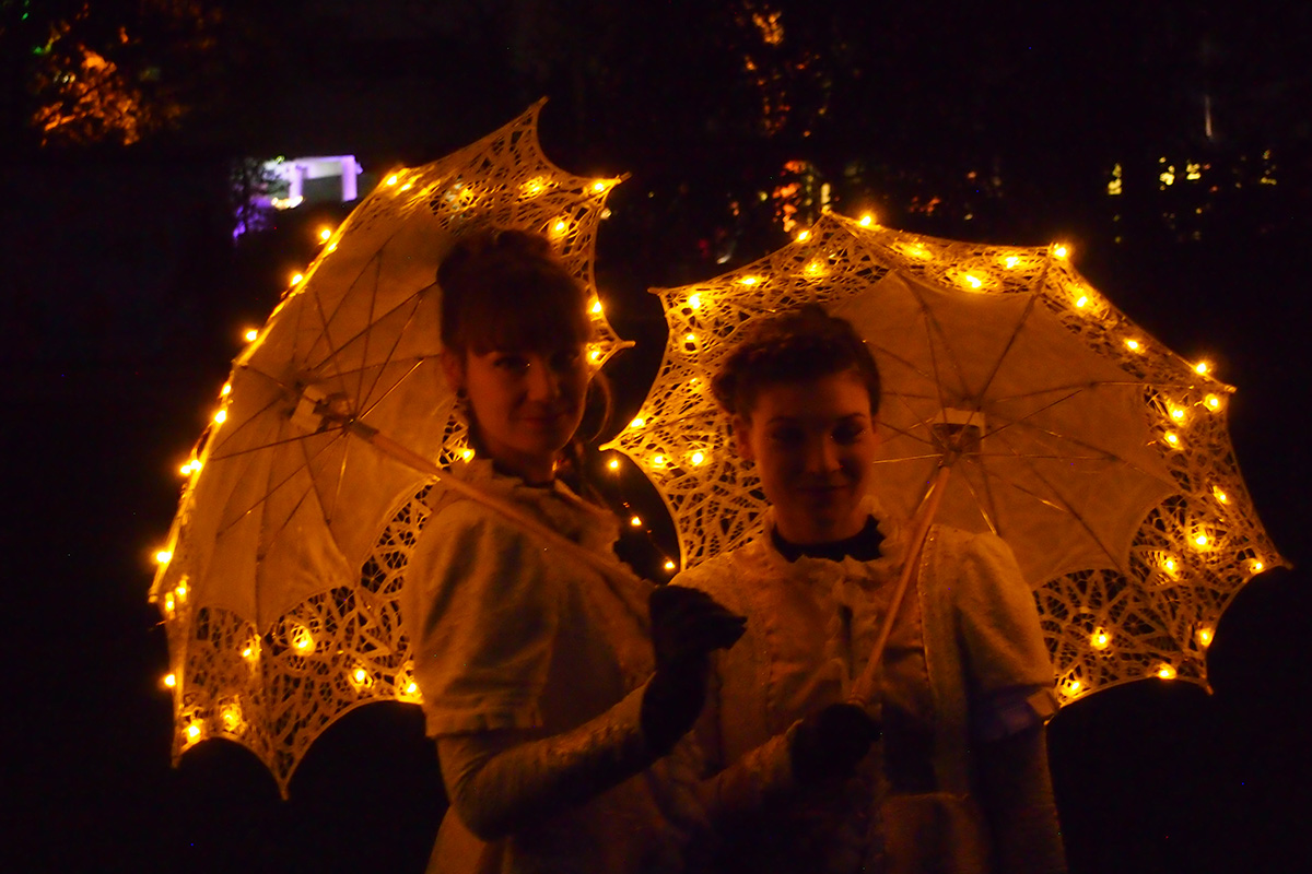 Kaksi naista valaistujen päivänvarjojen kanssa.