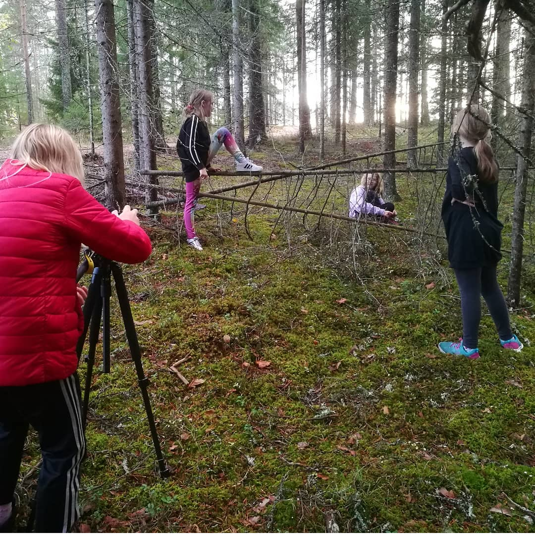 Tyttöjä metsässä kameran kanssa.